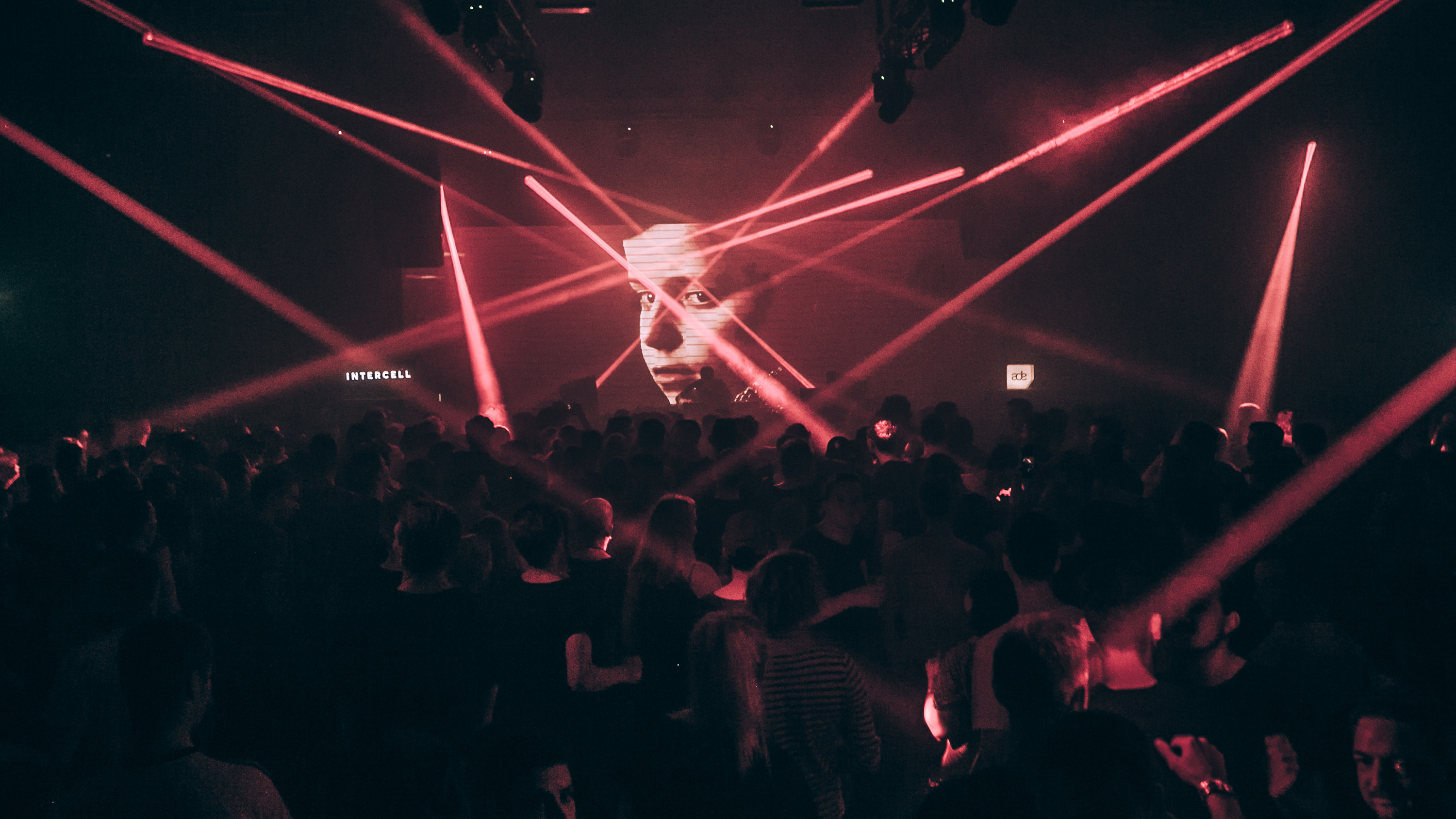 Intercell techno event crowd and warehouse production at Amsterdam Dance Event with dramatic industrial lighting